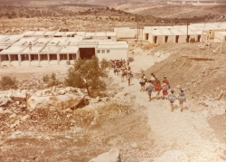 יורדים לבית הספר החדש. מימין - סימון אתר הבניה לבית הכנסת. מתחתיו האשקוביות של גרעין מעוז עליה.
על הגבעה שמאחורי בית הספר ייבנו בהמשך בתי יישוב הקבע 
(באדיבות ורדה ויהודה דוידסון, 2024)